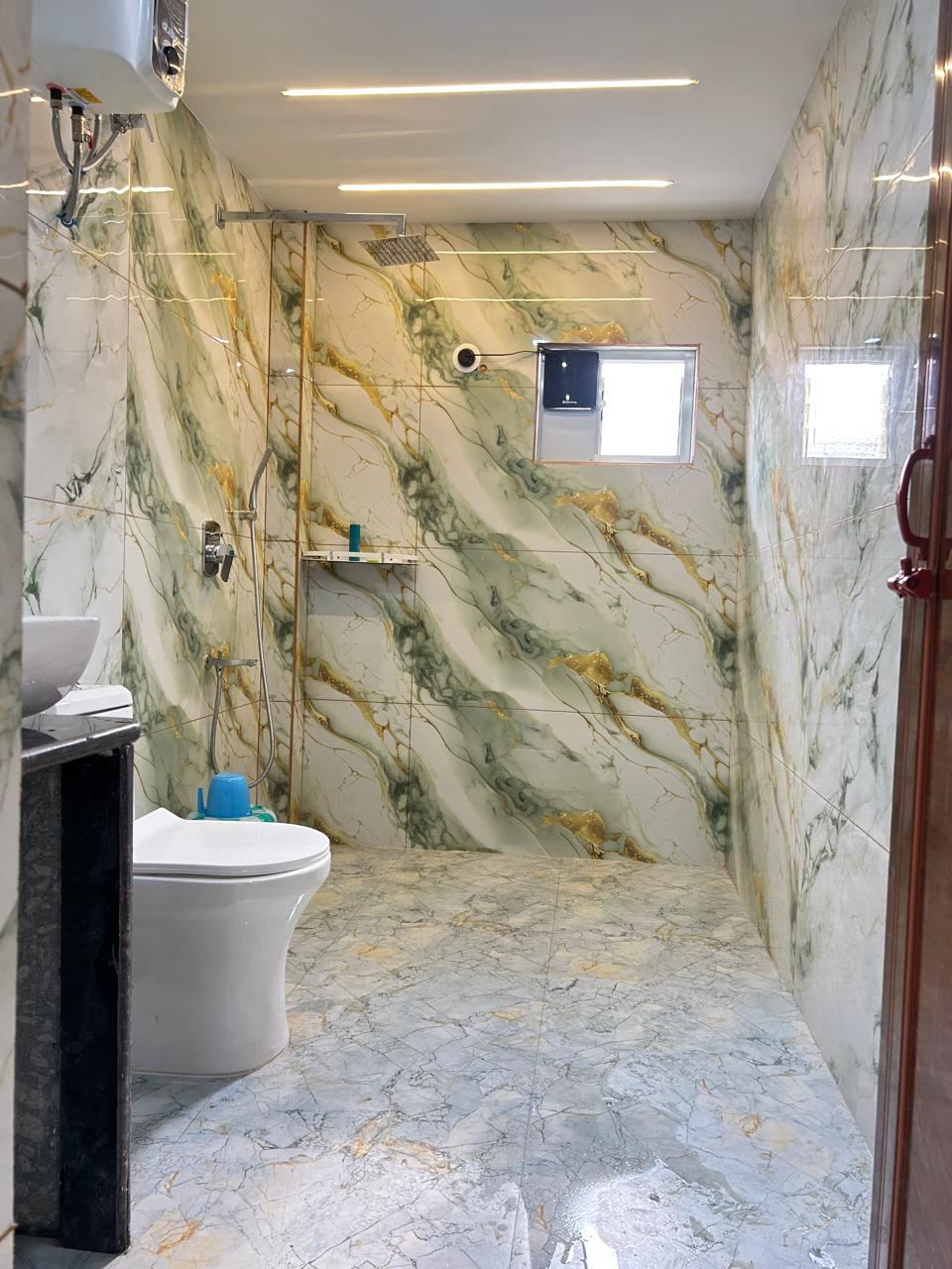 Modern cottage bathroom with marble tile and rain shower at Chamtaburu Eco Village, Ajodhya Hills